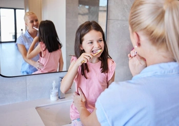 Gentle brushing technique along the gumline with a soft-bristled toothbrush
