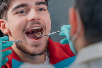 Dentist examining a patient's mouth to find the source of tooth pain